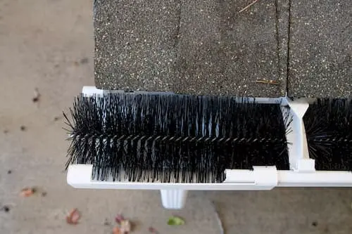 Brush gutter insert with Douglas fir needles woven into bristles — impossible to rinse clean, requiring full removal