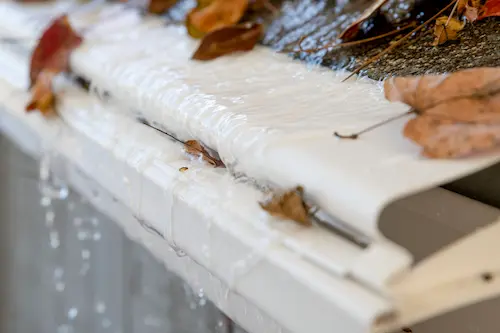 Reverse-curve gutter guard showing how water overshoots the gutter channel during heavy rainfall in Victoria BC